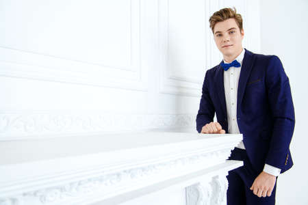 Handsome young man in elegant suit posing in luxurious apartments. Male beauty, fashion.の写真素材