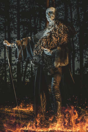 Zombie warrior in knightly armor stands in the night forest. Fantasy horror film. Halloween.の写真素材