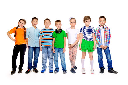 Group of happy children wearing bright clothes standing together. Kid's fashion. Education. Isolated over white. Full length portrait.の写真素材