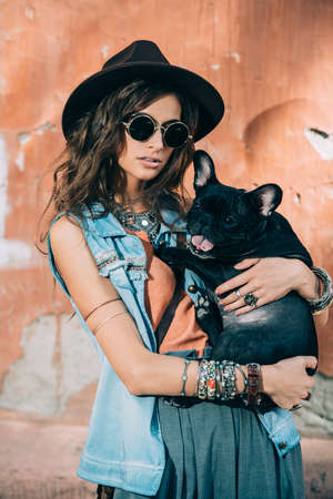 Sexual young woman posing with a dog in jeans clothes on a street.の写真素材