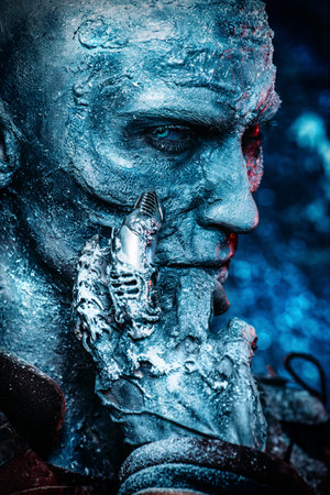 Close-up portrait of a zombie man covered with snow. Halloween. Horror film.