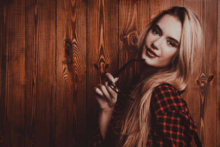 Portrait of a pretty blonde girl over wooden background. Beauty, youth fashion.の写真素材