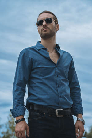 Handsome young man in jeans clothes stands on a city street. Men's fashion.の写真素材