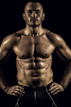 Portrait of a handsome athletic man with perfect muscular body over black background. Bodybuilding concept. Healthy lifestyle.の写真素材