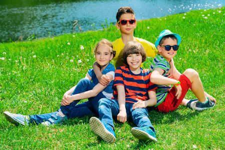 Group of cheerful children resting in the park. Outdoor activity. Summer holidays.の写真素材