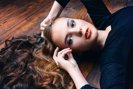 Beautiful girl with long curly hair. Beauty, fashion. Healthy hair, haircare cosmetics.の写真素材