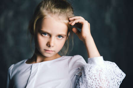 Portrait of a beautiful eight year old girl with calm pensive look. Childhood concept.の写真素材