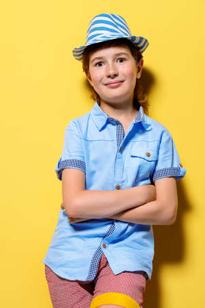 Portrait of a happy smiling boy over bright yellow background. Kid's fashion.の写真素材
