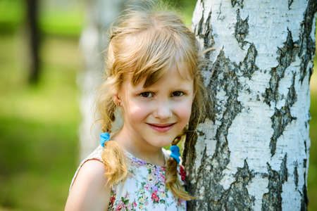 Cute little girl walking in a summer park. Sunny day.の写真素材