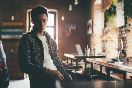 Handsome young man spends time in a wine restaurant.の写真素材