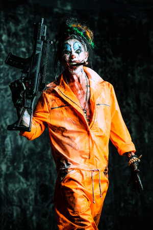 Crazy evil clown man stained in blood is smoking a cigar and holding a gun. Halloween. Horror,...