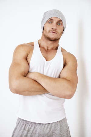 Portrait of a handsome athletic man posing in casual clothes in white room. Health and sports. Bodybuilding.の写真素材