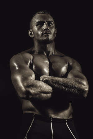 Portrait of a handsome athletic man with perfect muscular body over black background. Bodybuilding concept. Healthy lifestyle.の写真素材