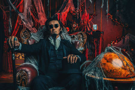 Halloween. Mysterious gloomy man in a black tailcoat in an old abandoned castle. The Dark Lord. Vampire man.の写真素材