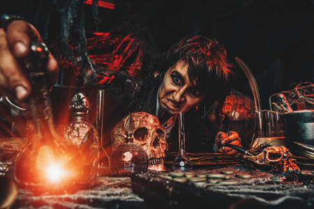 Medieval scientist creates a magical elixir in his laboratory. Alchemist. Halloween.の写真素材