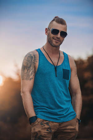 Portrait of a masculine handsome man in casual clothes standing outdoor. Men's fashion.の写真素材