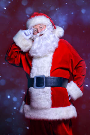 Christmas concept. Portrait of a fairytale Santa Claus over red background. Good old traditions. Family holidays.の写真素材
