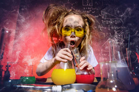 Funny little girl doing experiments in the laboratory. Explosion in the laboratory. Science and education.の写真素材