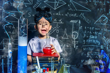 Little boy doing experiments in the laboratory. Explosion in the laboratory. Science and education.の写真素材
