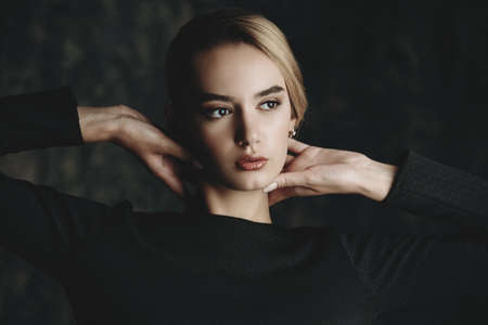 Portrait of a beautiful elegant young woman wearing black dress. Beauty, fashion concept. Make-up and cosmetics. Studio shot.の写真素材