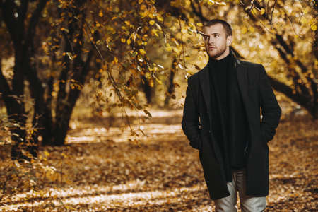 Modern handsome man in the autumn park. Seasonal fashion.の写真素材