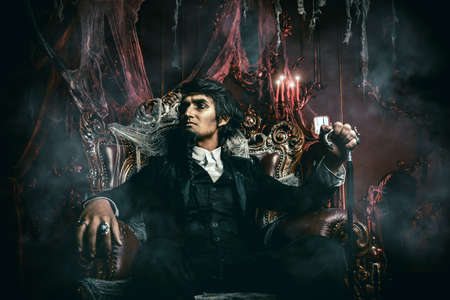 Halloween. Mysterious gloomy man in a black tailcoat in an old abandoned castle. The Dark Lord. Vampire man.の写真素材