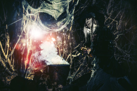 The old witch cooks a sorcery potion in the thicket of the forest. Fairy tales on Halloween.