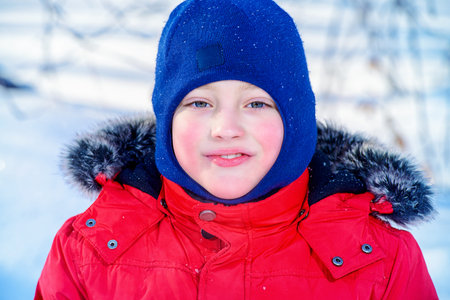 Happy child boy enjoys sunny winter day.