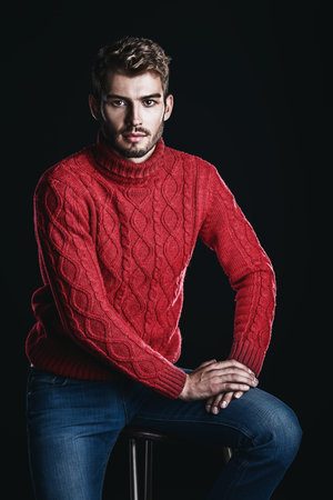 Portrait of a handsome young man in a warm sweater. Autumn, winter clothes. Male beauty, fashion.の写真素材