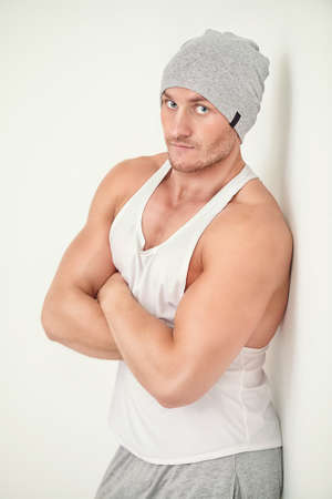 Portrait of a handsome athletic man posing in casual clothes in white room. Health and sports. Bodybuilding.の写真素材