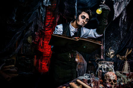 Medieval scientist creates a magical elixir in his laboratory. Alchemist. Halloween.の写真素材