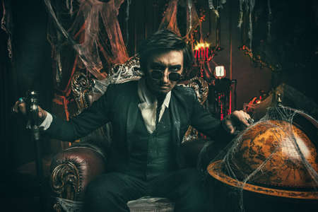 Halloween. Mysterious gloomy man in a black tailcoat in an old abandoned castle. The Dark Lord. Vampire man.の写真素材