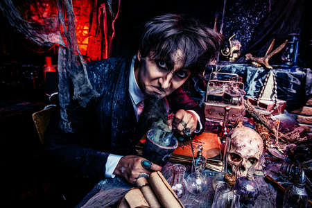 Portrait of a medieval scientist working in his laboratory. Alchemist. Halloween.の写真素材