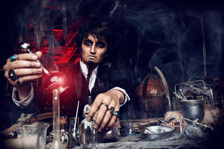 Medieval scientist creates a magical elixir in his laboratory. Alchemist. Halloween.の写真素材