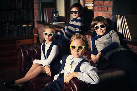 Group of modern children posing in school uniform and sunglasses in luxurious apartments. School fashion.の写真素材