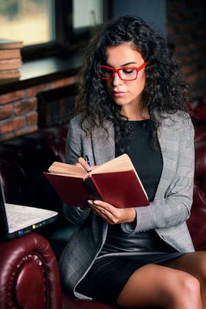 Businesswoman is working with her laptop and diary at the office.の写真素材