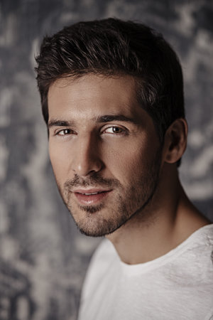 Portrait of a handsome young man wearing white t-shirt. Studio shot. Men's beauty and health.の写真素材