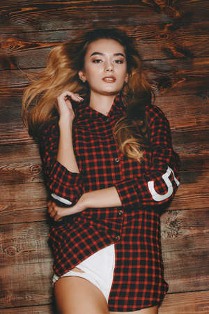 Portrait of a pretty blonde girl over wooden background. Beauty, youth fashion.の写真素材