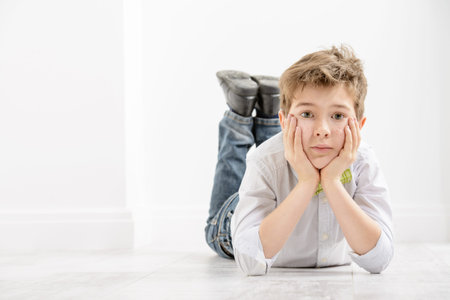 Fashion concept. Cute nine year old boy in elegant clothes posing in a room with classic white...