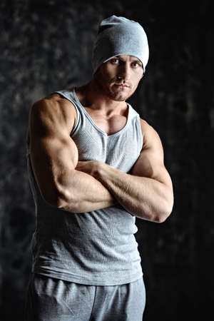 Handsome athletic man posing over grunge background. Bodybuilding concept. Healthy lifestyle.の写真素材