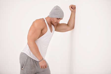 Portrait of a handsome athletic man posing in casual clothes in white room. Health and sports. Bodybuilding.の写真素材