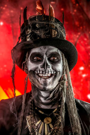 A man with a skull makeup dressed in a tail-coat and a top-hat. Baron Saturday. Baron Samedi. Dia de los muertos. Day of The Dead. Halloween.の写真素材