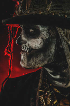 A man with a skull makeup dressed in a tail-coat and a top-hat. Baron Saturday. Baron Samedi. Dia de los muertos. Day of The Dead. Halloween.の写真素材