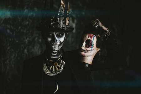 A man with a skull makeup dressed in a tail-coat and a top-hat. Baron Saturday. Baron Samedi. Dia de los muertos. Day of The Dead. Halloween.の写真素材
