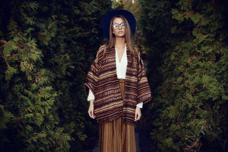 Fashion shot. Beautiful young woman in stylish clothes in the park. Ethnics, boho style.の写真素材
