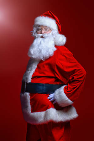 Christmas concept. Portrait of a fairytale Santa Claus over red background. Good old traditions. Family holidays.の写真素材
