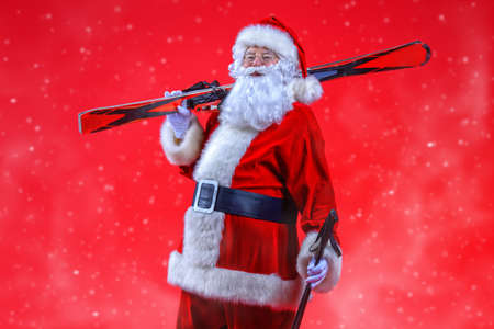 Portrait of Santa Claus holding skiing. Christmas holidays and winter activities.の写真素材