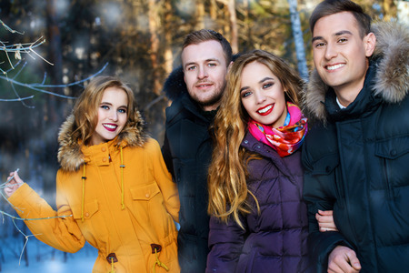Young people in the forest. Fashion shot. Down Jackets.