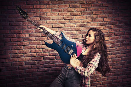 Portrait of an attractive girl with electric guitar. Rock music.の写真素材