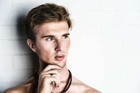 Close-up portrait of a handsome young man with naked torso. Male beauty, health.の写真素材